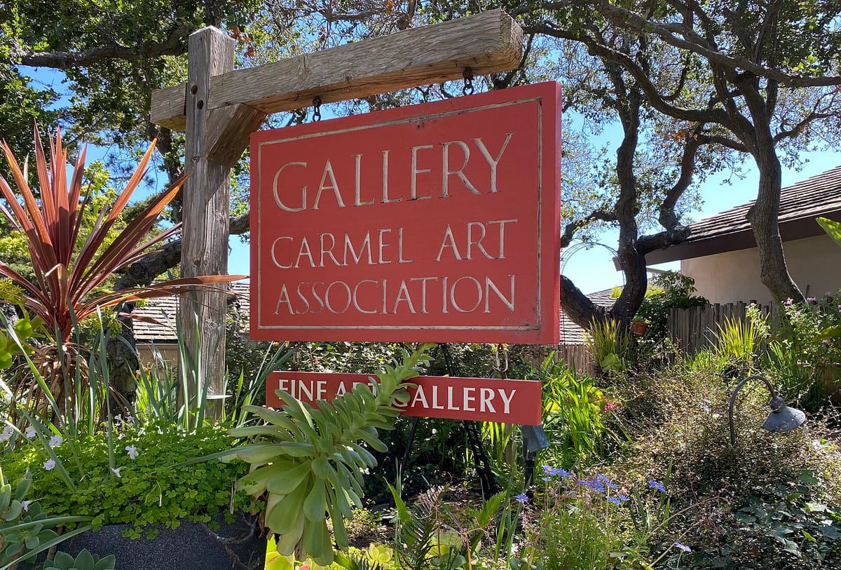 The hanging sign of the Carmel Art Association gallery on Dolores Street